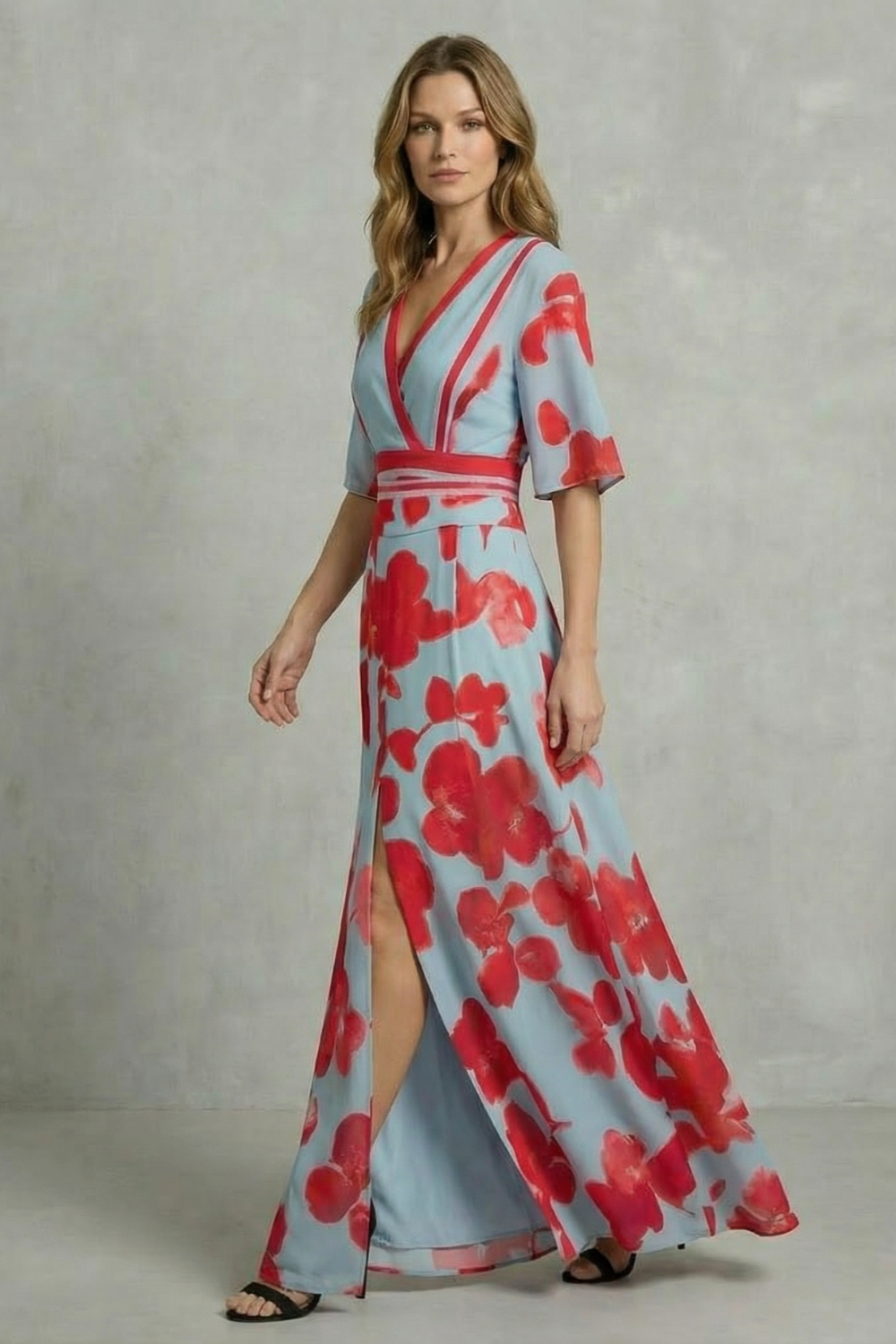 Women's light blue and red floral maxi dress walking pose, showing leg through front slit and V-neck