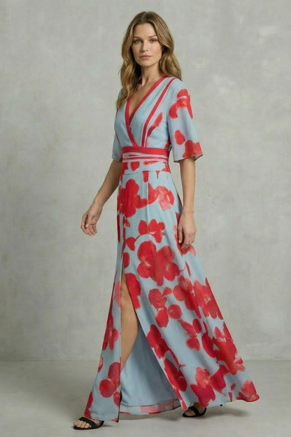 Women's light blue and red floral maxi dress walking pose, showing leg through front slit and V-neck