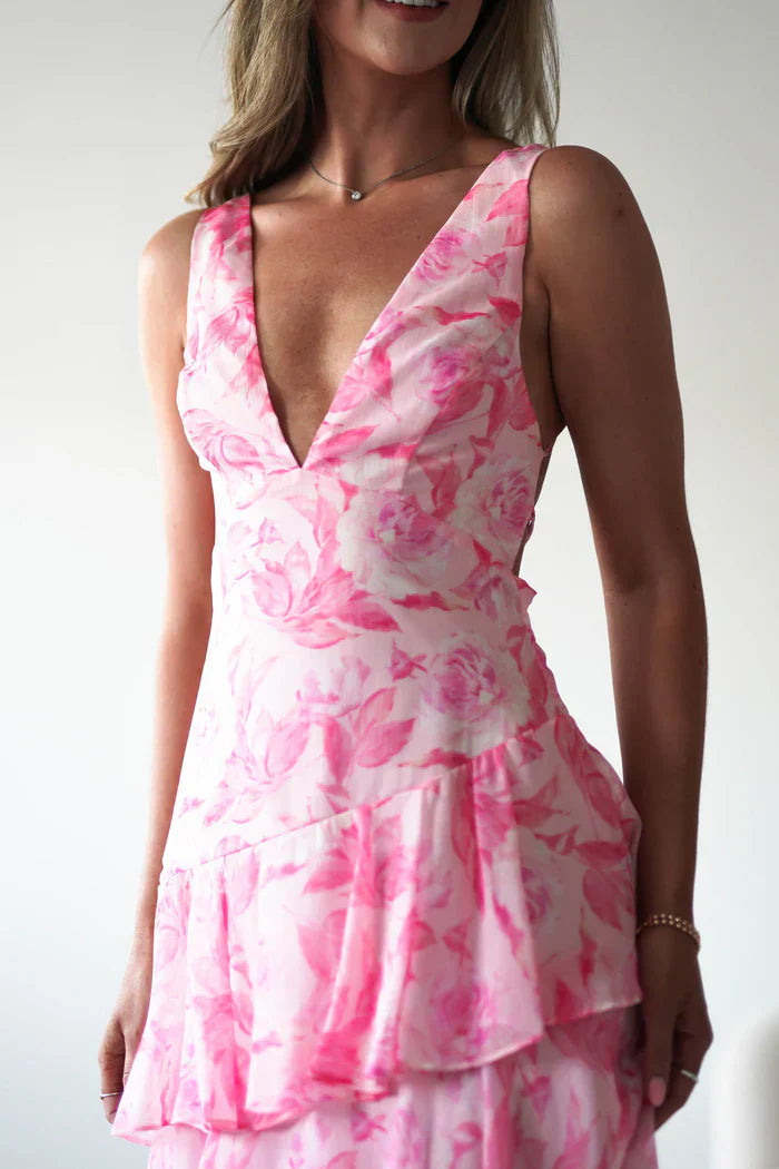 Close-up of a women's summer floral V-neck tiered maxi dress in pink with delicate rose patterns and a deep V-neckline.