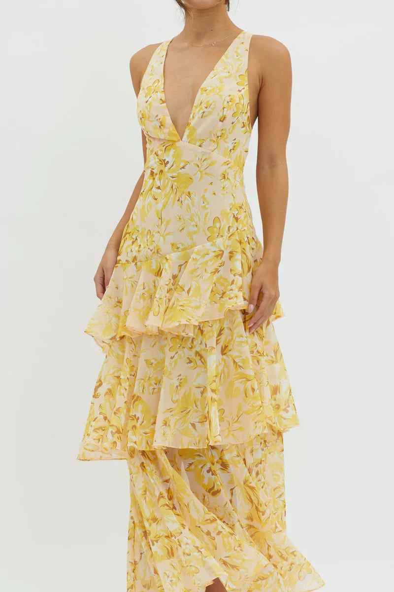 Close-up of a women's summer floral v-neck tiered maxi dress, showcasing the yellow and white floral print and ruffled layers.