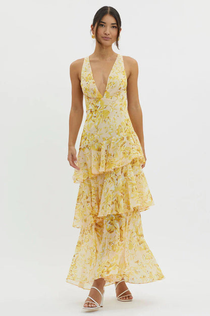 Full-length view of a women's floral v-neck tiered maxi dress in yellow, featuring a deep v-neckline and flowy skirt with ruffles.