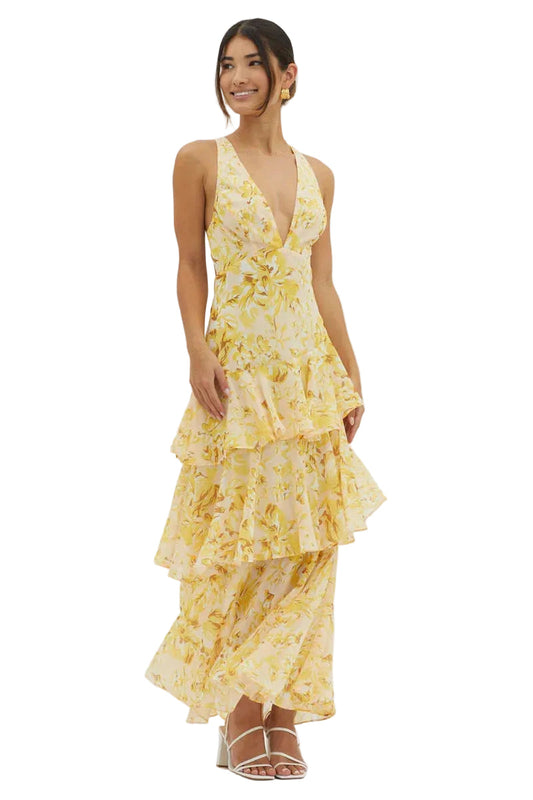 Women's summer floral v-neck tiered maxi dress in light yellow with intricate floral patterns and ruffled skirt, styled with white heels.