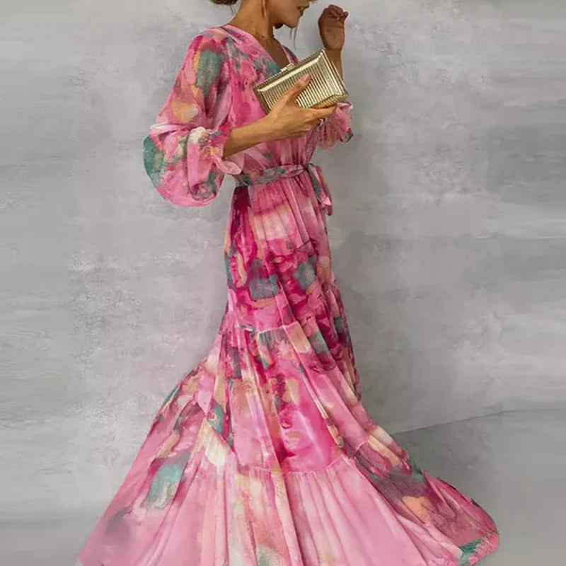 Side view of pink floral tiered maxi dress with belted waist and flowing skirt, lightweight sheer sleeves
