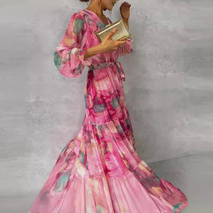 Side view of pink floral tiered maxi dress with belted waist and flowing skirt, lightweight sheer sleeves