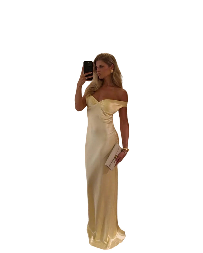 Full-length view of a women's formal off-shoulder yellow satin maxi dress, with a fitted bodice and long skirt.