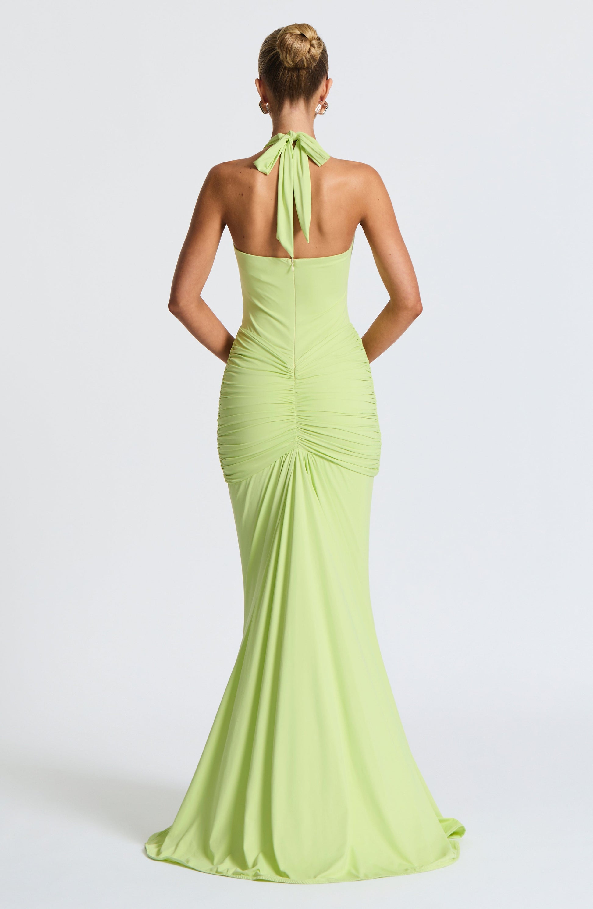Back view lime green halter maxi dress with tie neck, fitted ruched skirt, and center back seam