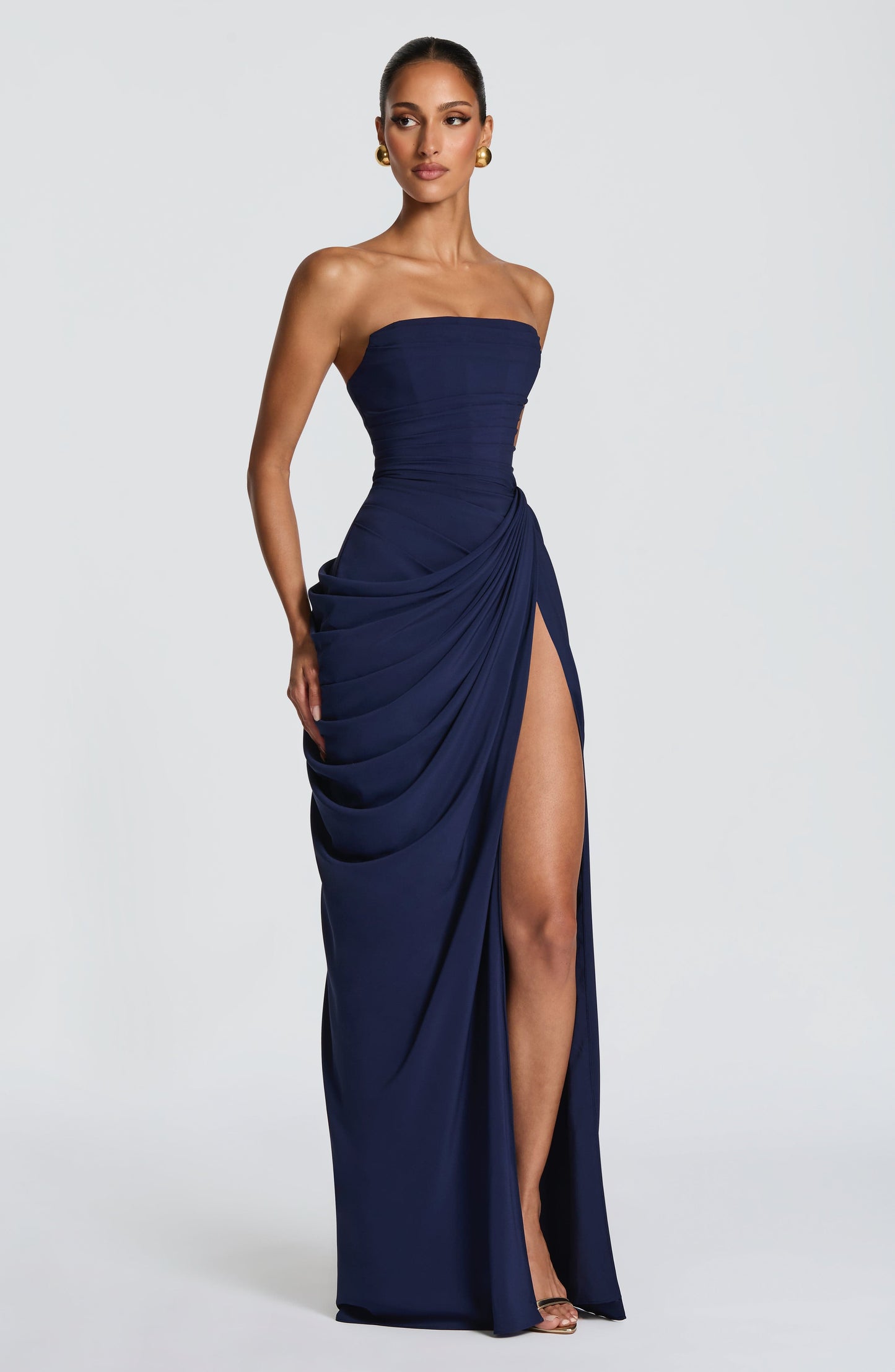 Three-quarter navy strapless draped maxi dress showing gathered side drape and front slit opening