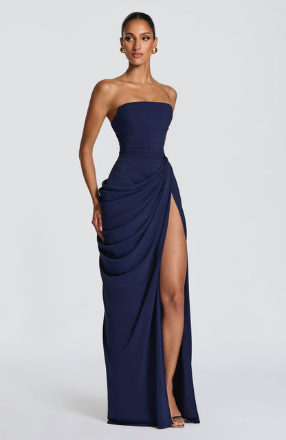 Three-quarter navy strapless draped maxi dress showing gathered side drape and front slit opening