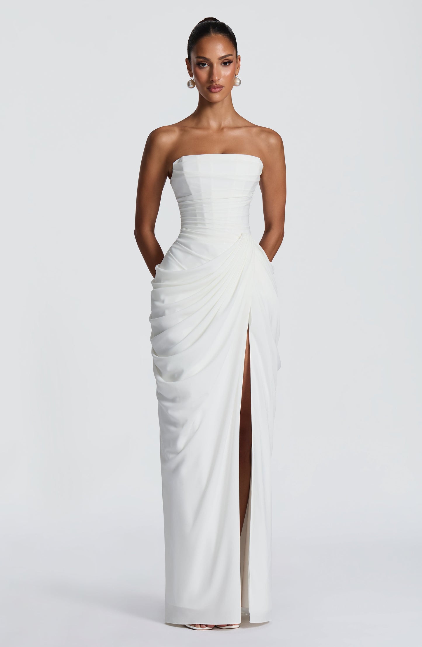 White strapless draped maxi dress front view with ruched bodice and center slit for formal wear