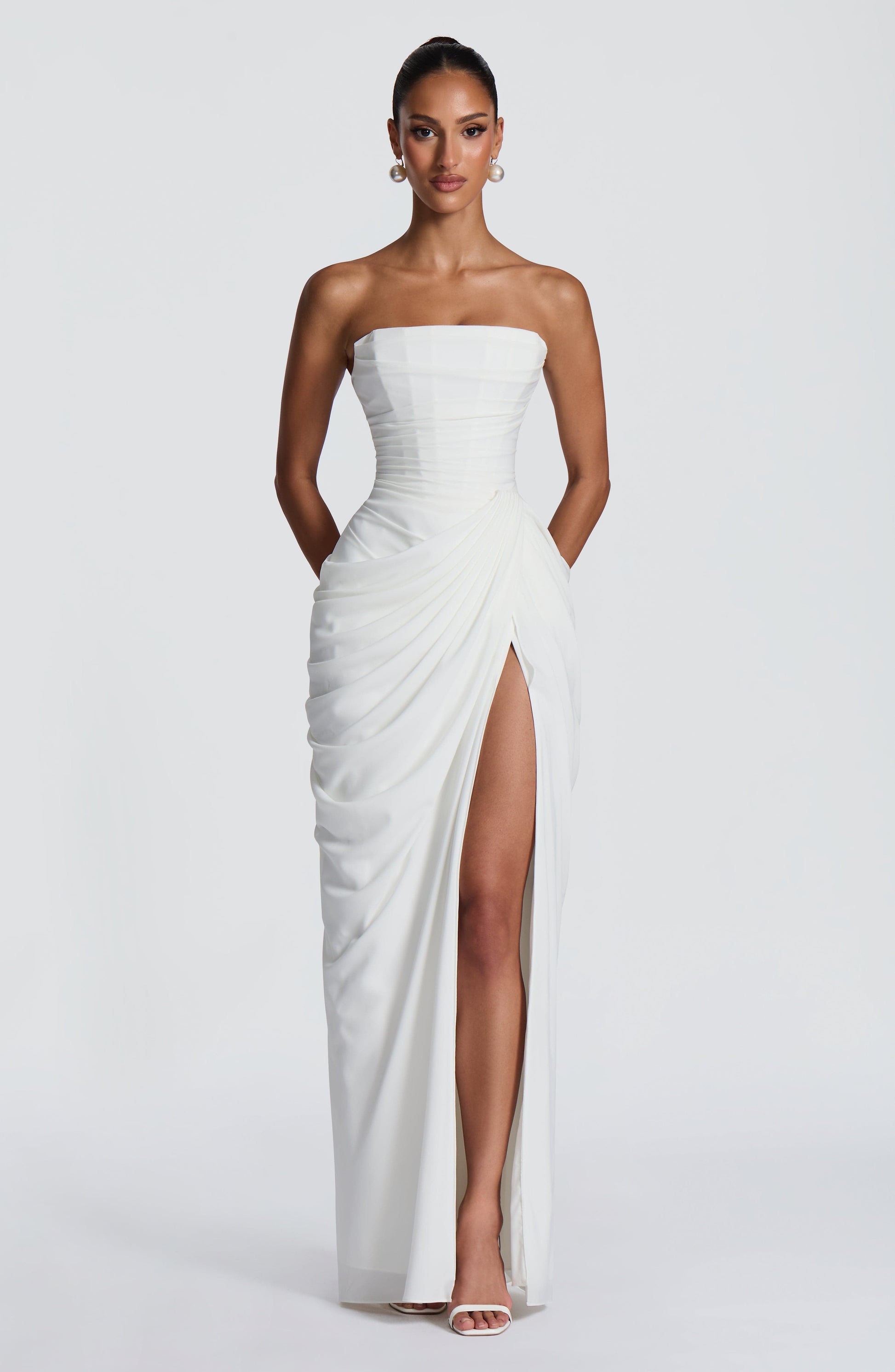 White formal strapless draped maxi dress with thigh slit, straight-on full-length silhouette