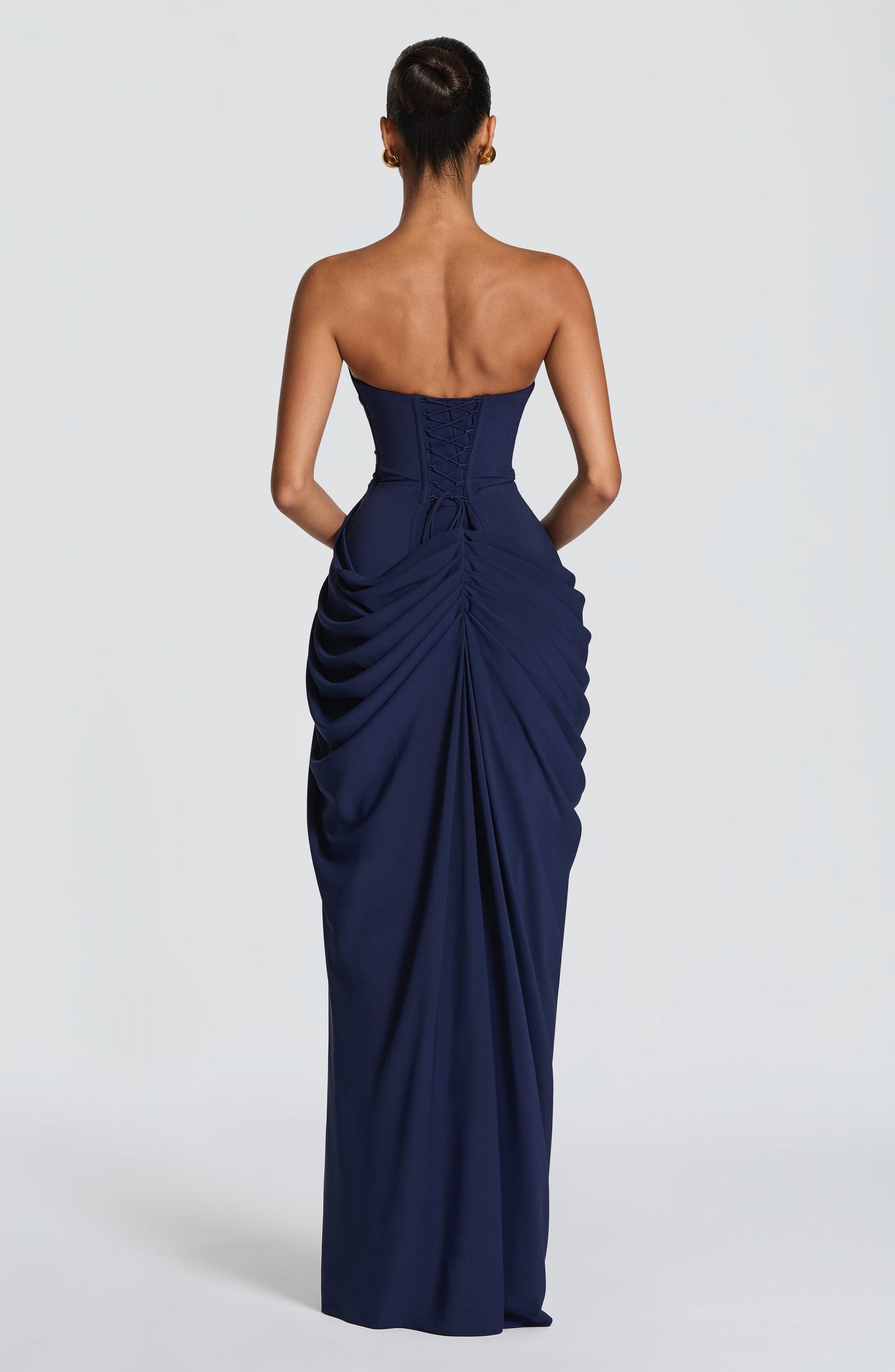 Back view navy strapless maxi dress with lace-up corset back and ruched draped skirt detail
