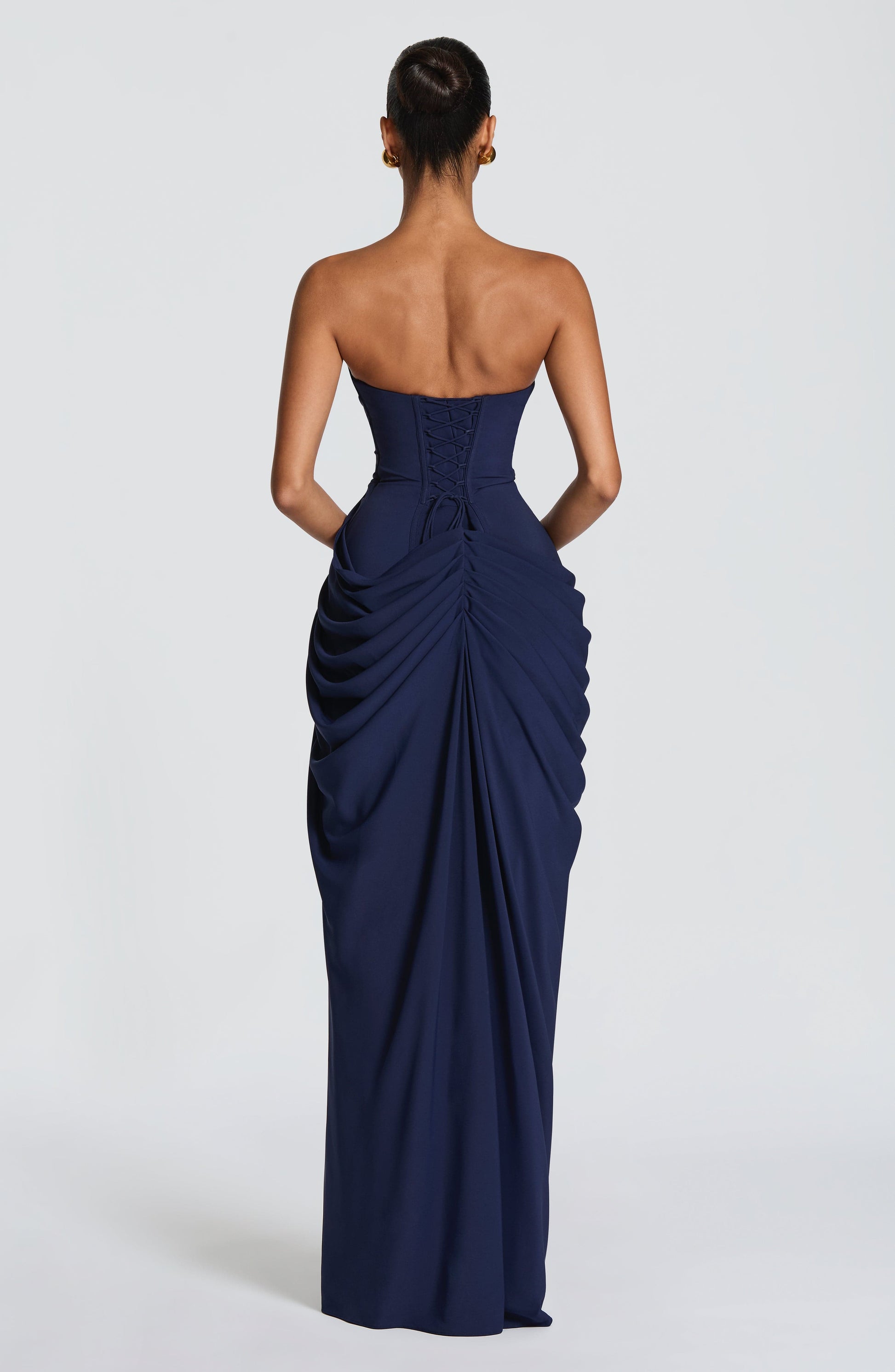 Back view navy strapless maxi dress with lace-up corset back and ruched draped skirt detail