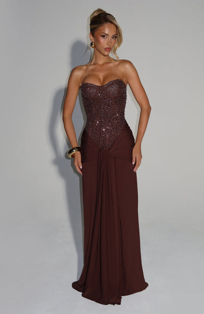Front view of chocolate brown strapless sequin corset maxi dress with draped knot waist and long skirt