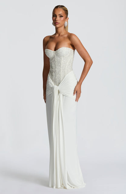 Angle view of white formal strapless sequin corset maxi dress with draped knot skirt and train