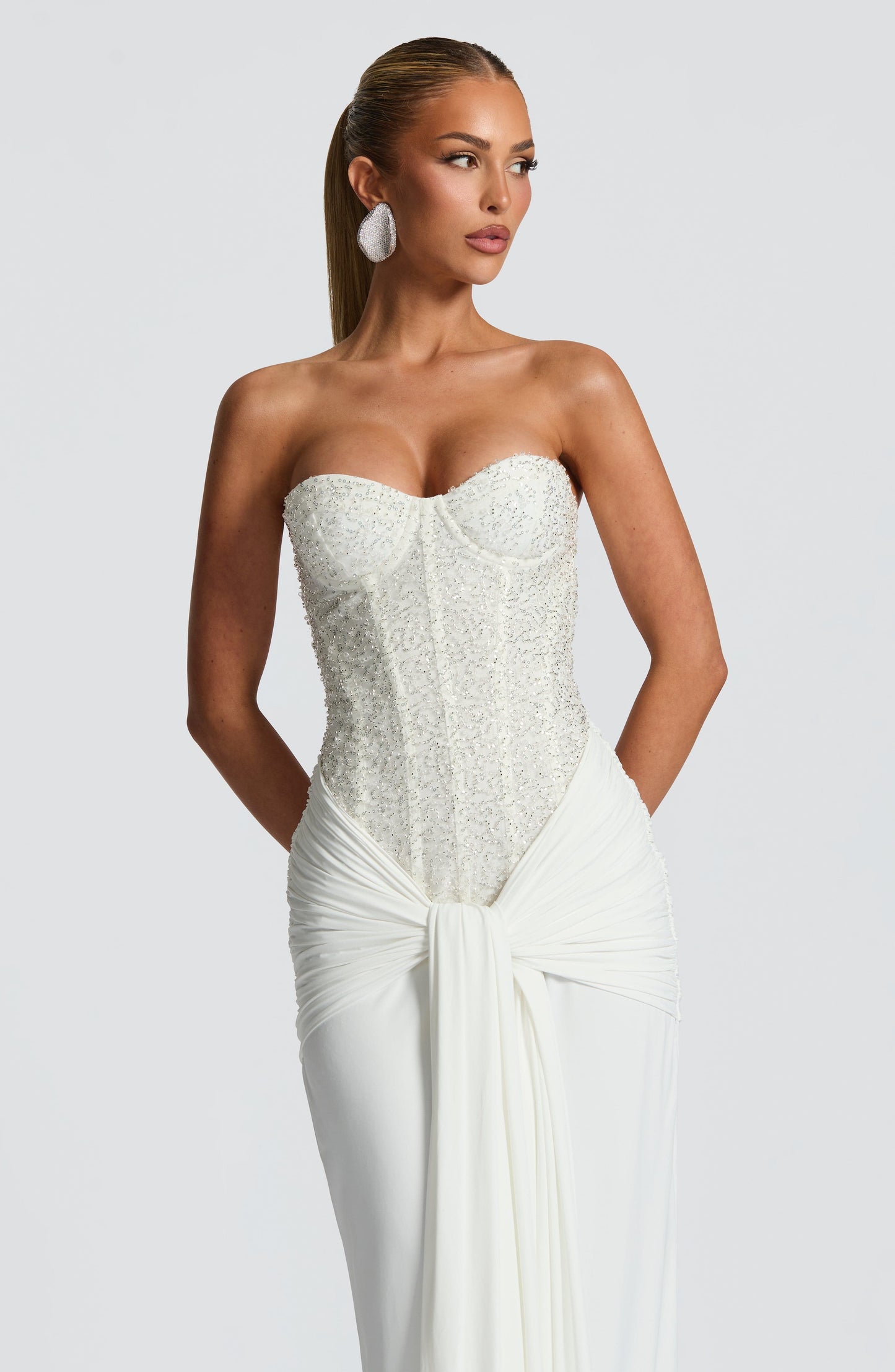 Close-up of white sequin corset bodice and ruched waist drape on strapless maxi dress, bodycon fit