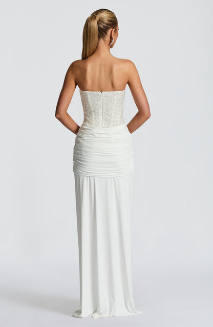 Back view of white strapless sequin corset maxi dress showing straight neckline, zipper, and ruched skirt