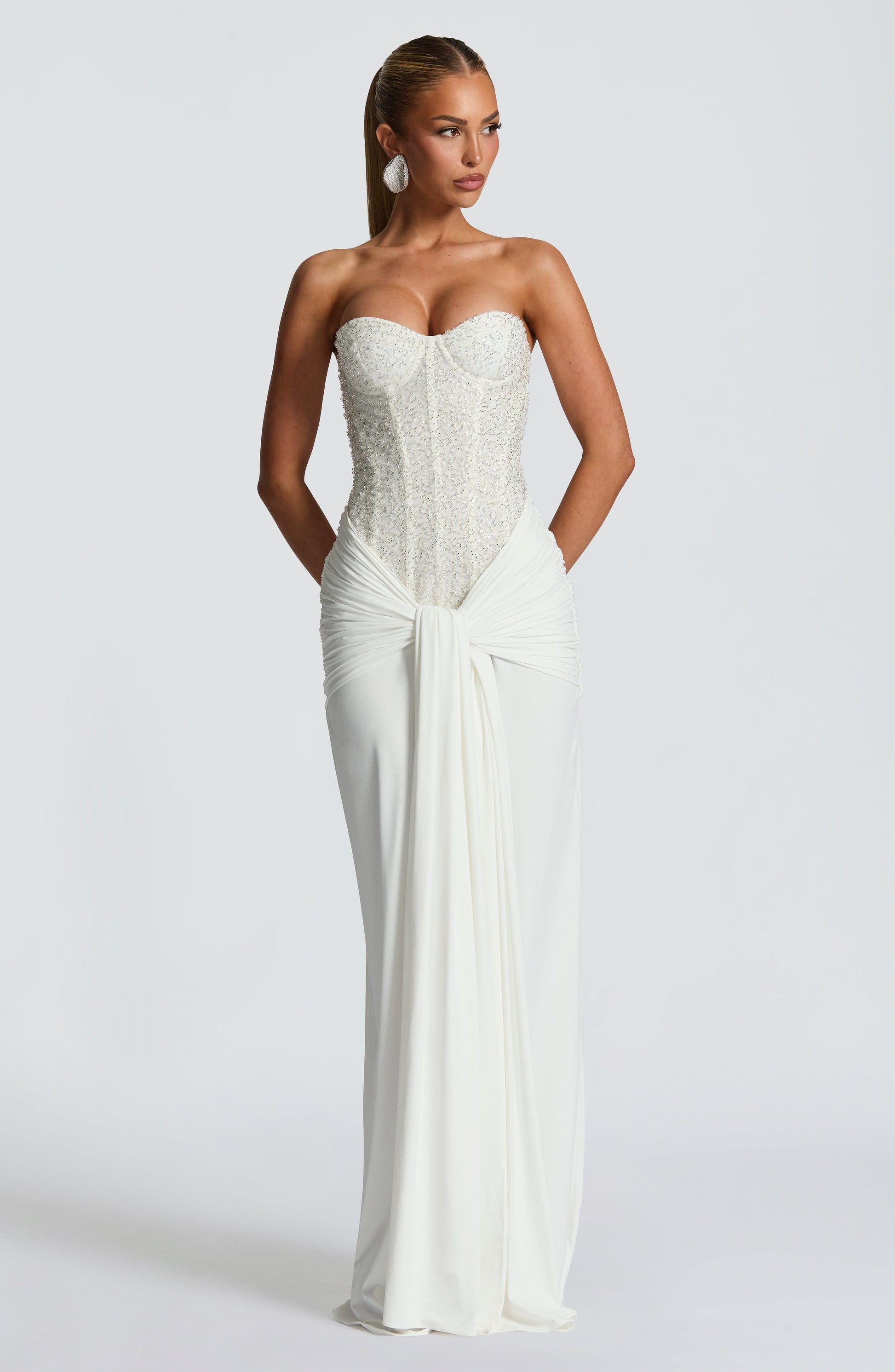 White strapless sequin corset maxi dress with ruched waist and front drape detail, full length view