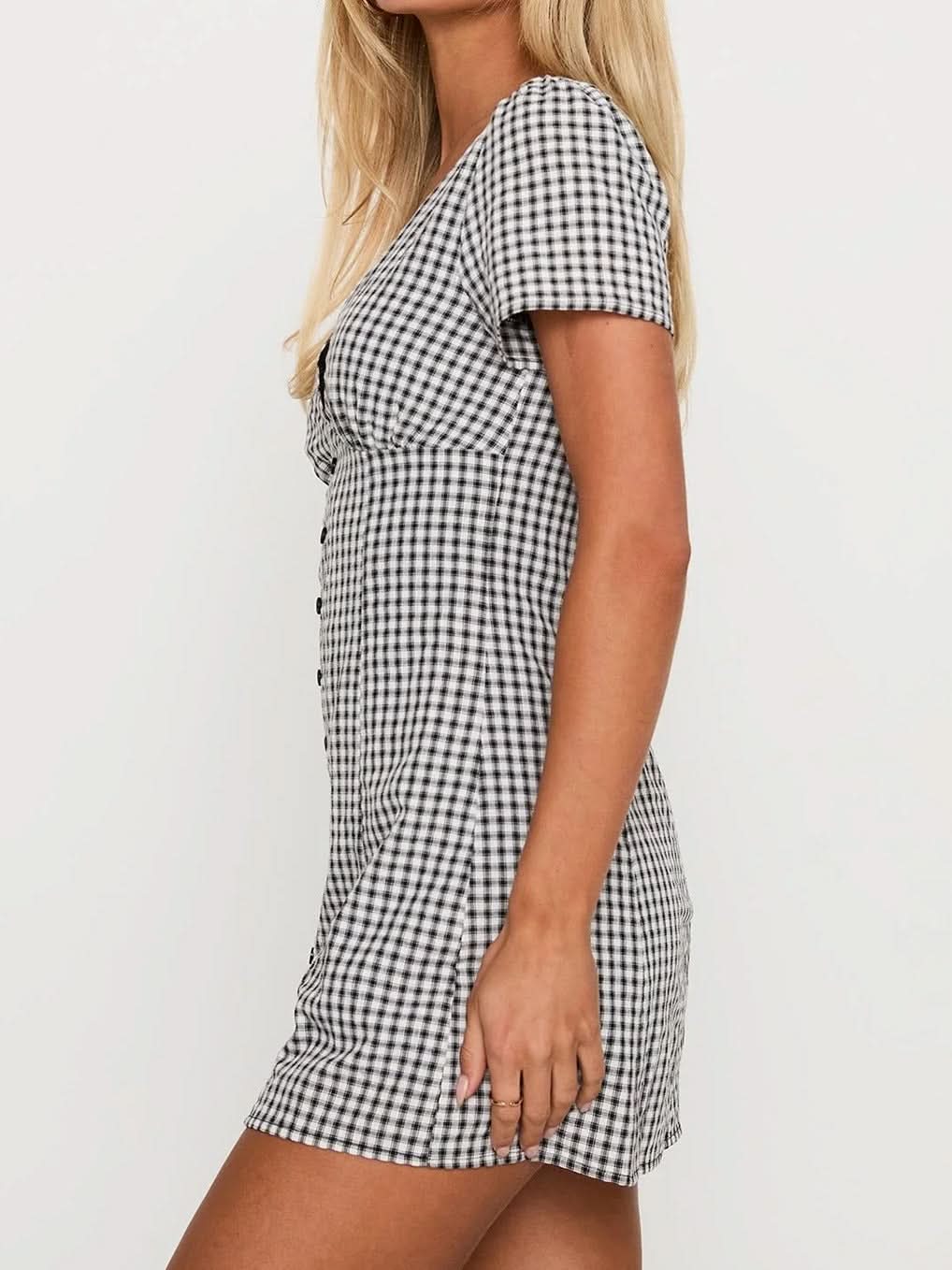 Black gingham mini playsuit side profile with fitted bodice, short sleeves and flared mini hem