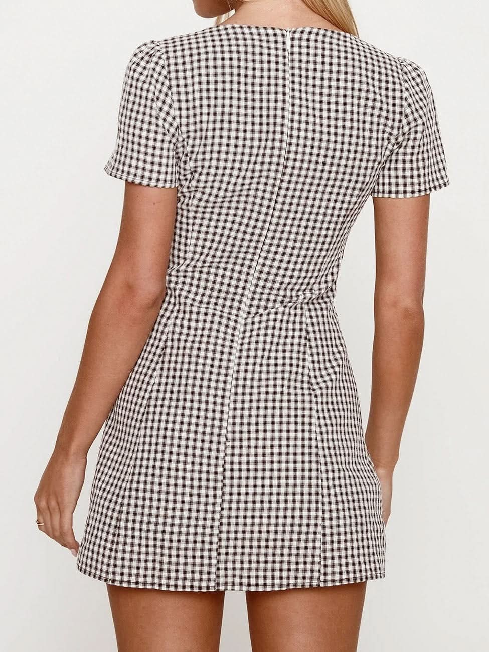 Back view of black and white gingham mini playsuit with fitted shape and short puff sleeves