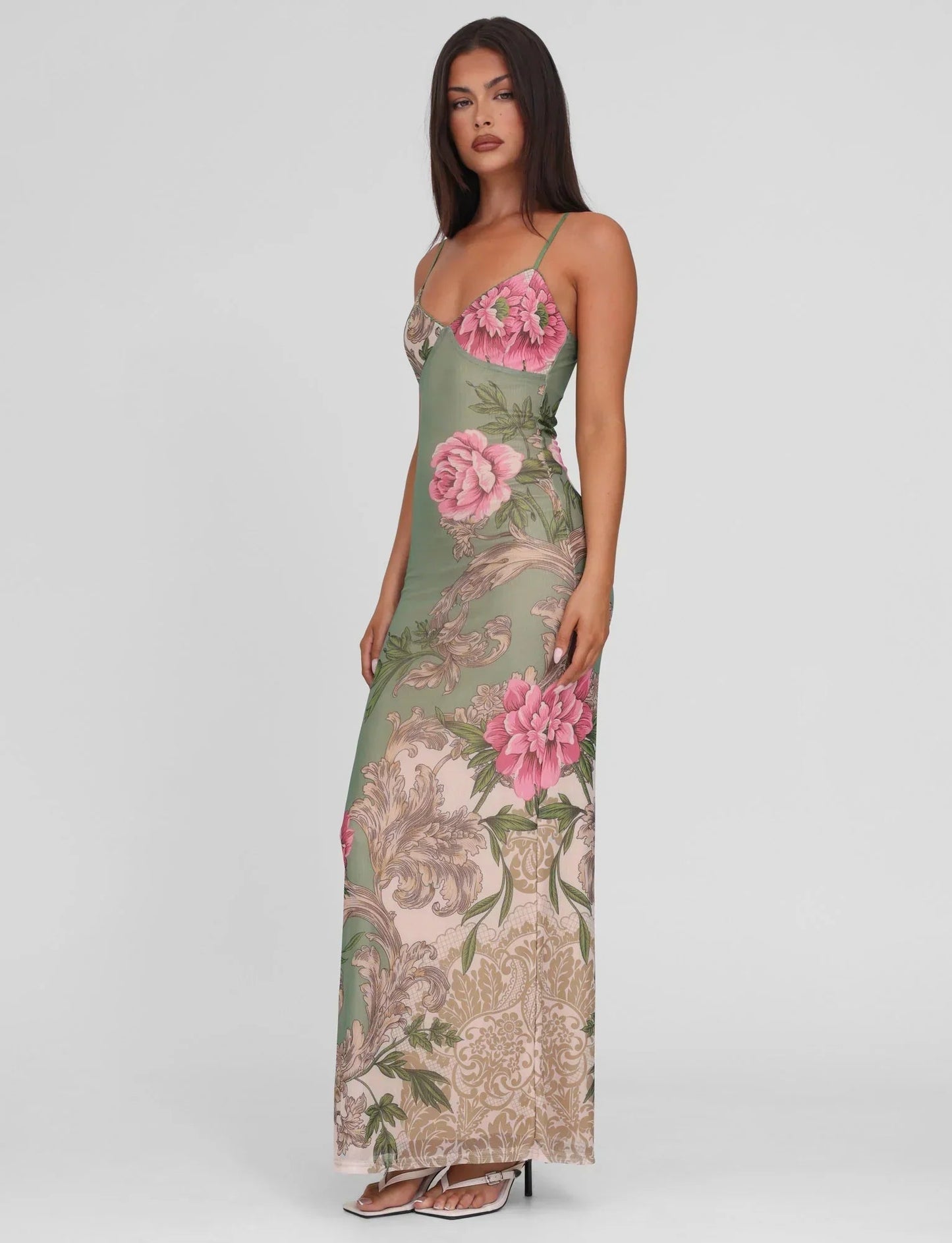 Side angle of sage green floral V-neck maxi dress, slim bodycon silhouette and pink blooms