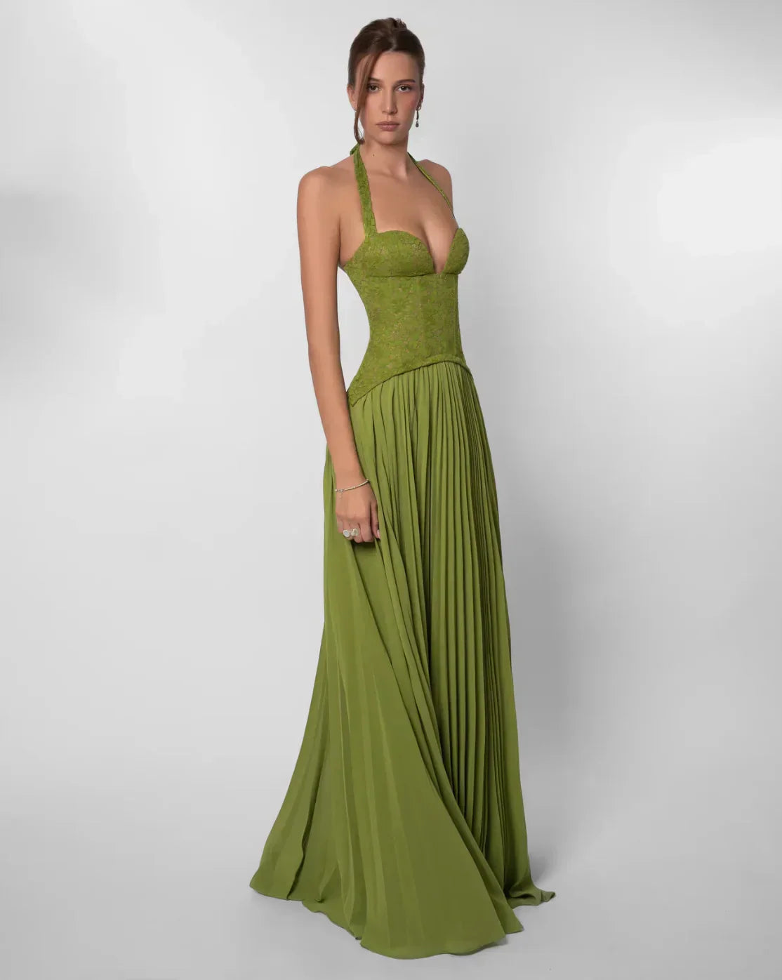Angled view of the olive green formal halter neck maxi dress, showcasing the pleated skirt and corset bodice.