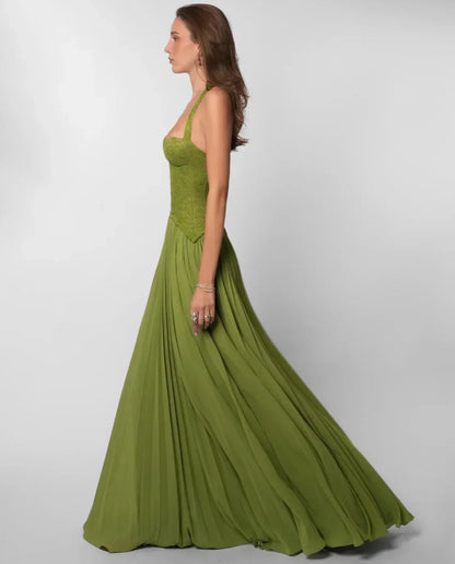 Side profile of the olive green formal halter neck maxi dress, emphasizing the flowing pleated skirt and corset top.