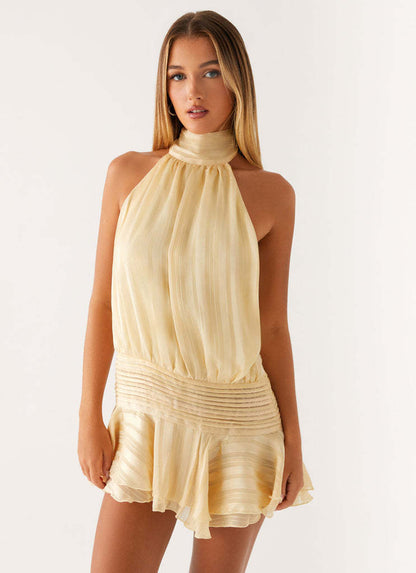 Frontal view of a women's light yellow halter neck ruched waist mini dress with a relaxed fit top.