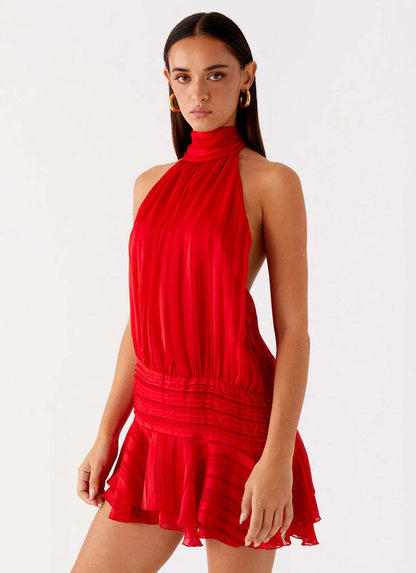 Close-up of a red halter neck mini dress, showcasing the ruched waist detail and subtle striped fabric texture.