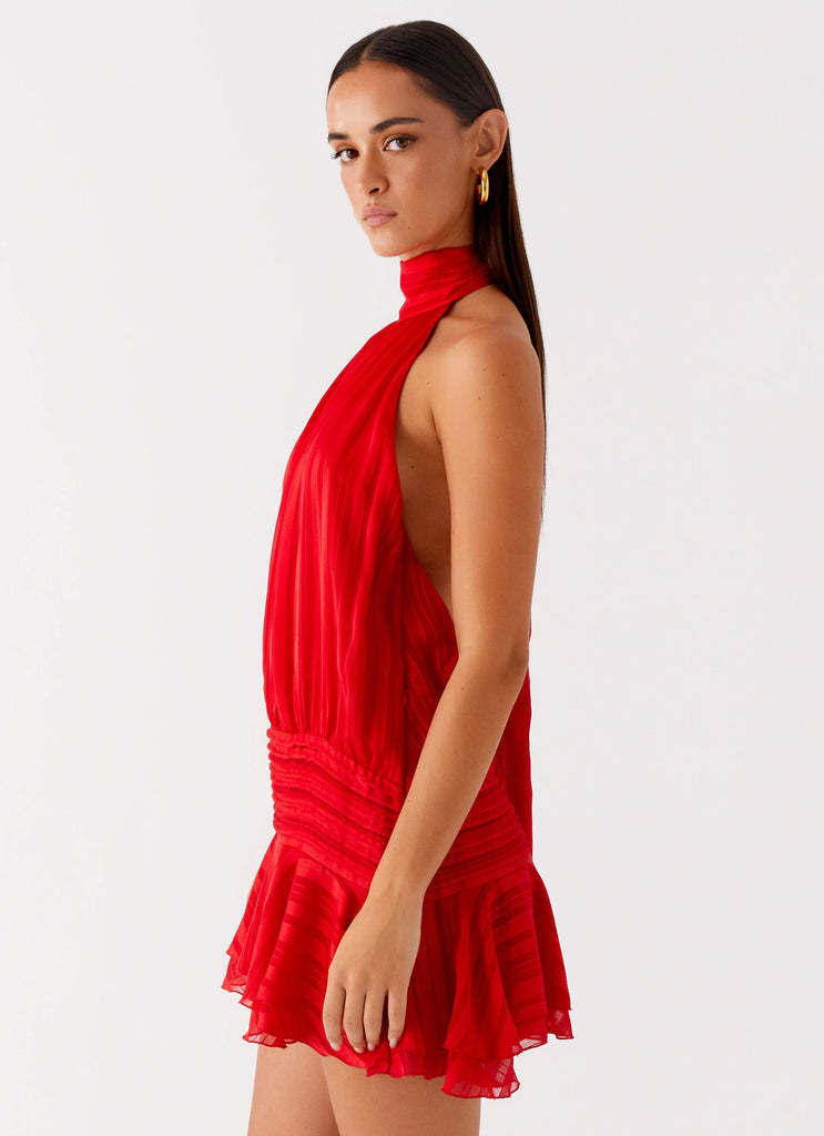 Side profile of women's red halter neck mini dress with ruched waist and tiered ruffled skirt detail, perfect for a party.