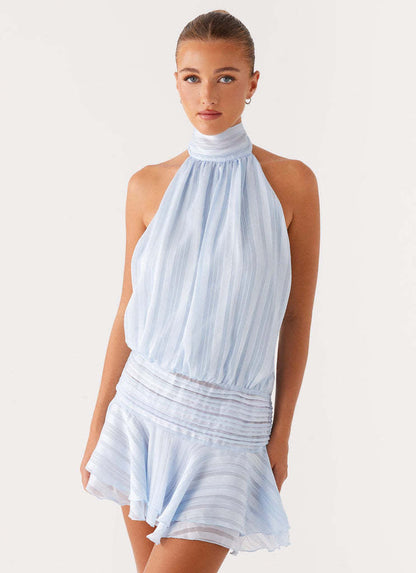 Light blue halter neck mini dress with ruched waist and subtle vertical stripes, featuring a ruffled hem.