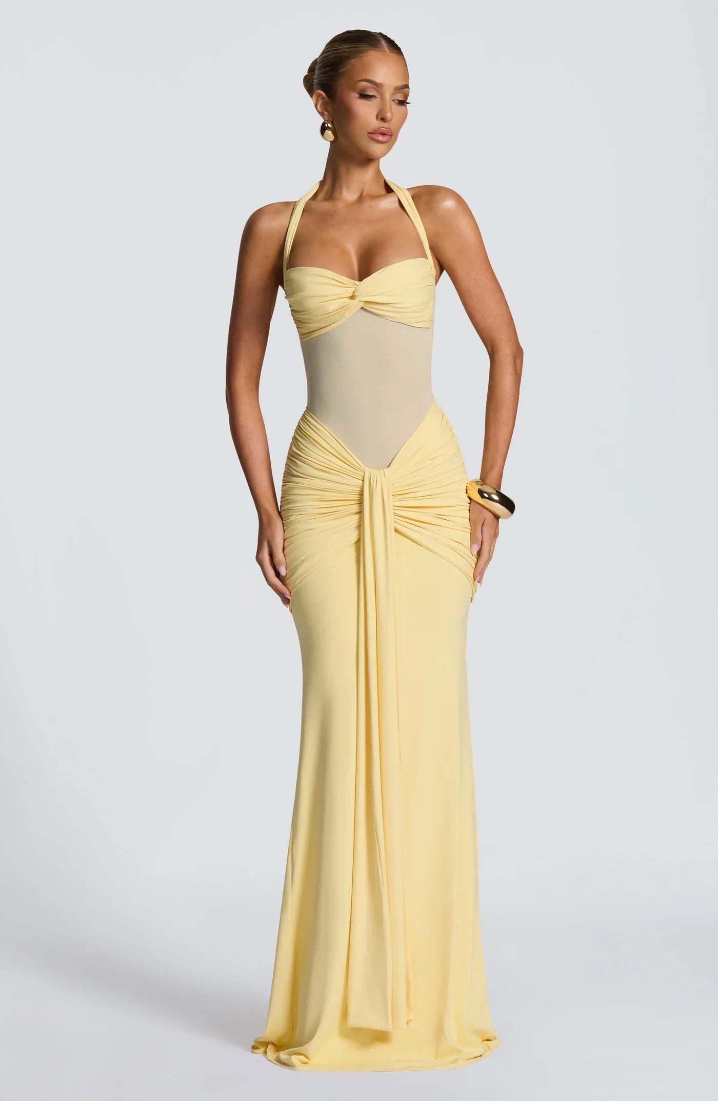 Full-length yellow halter neck twisted ruched maxi dress with a fitted silhouette, perfect for vacation outfits.