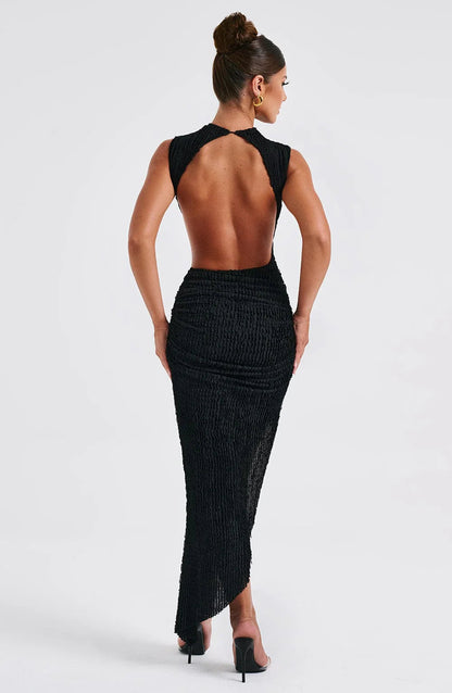 Full back view of the black high neck open back ruched midi dress, showcasing the open back detail and textured fabric.