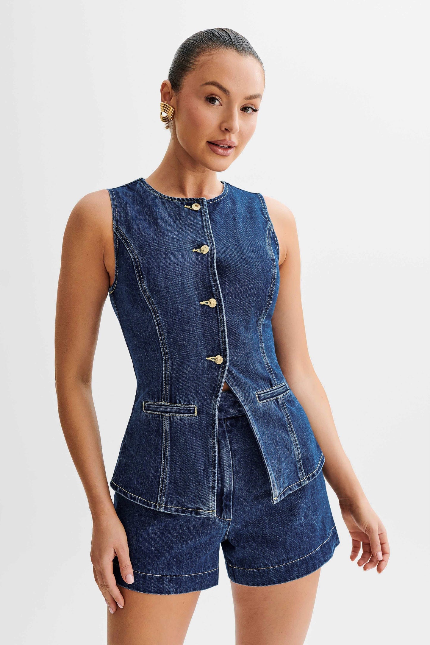 Close-up of dark wash denim vest top with gold buttons and seam detailing, two piece set