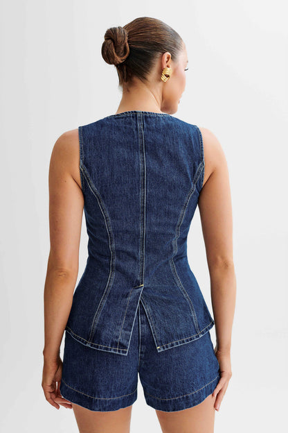 Back view of sleeveless dark wash denim vest and matching high waisted denim shorts set