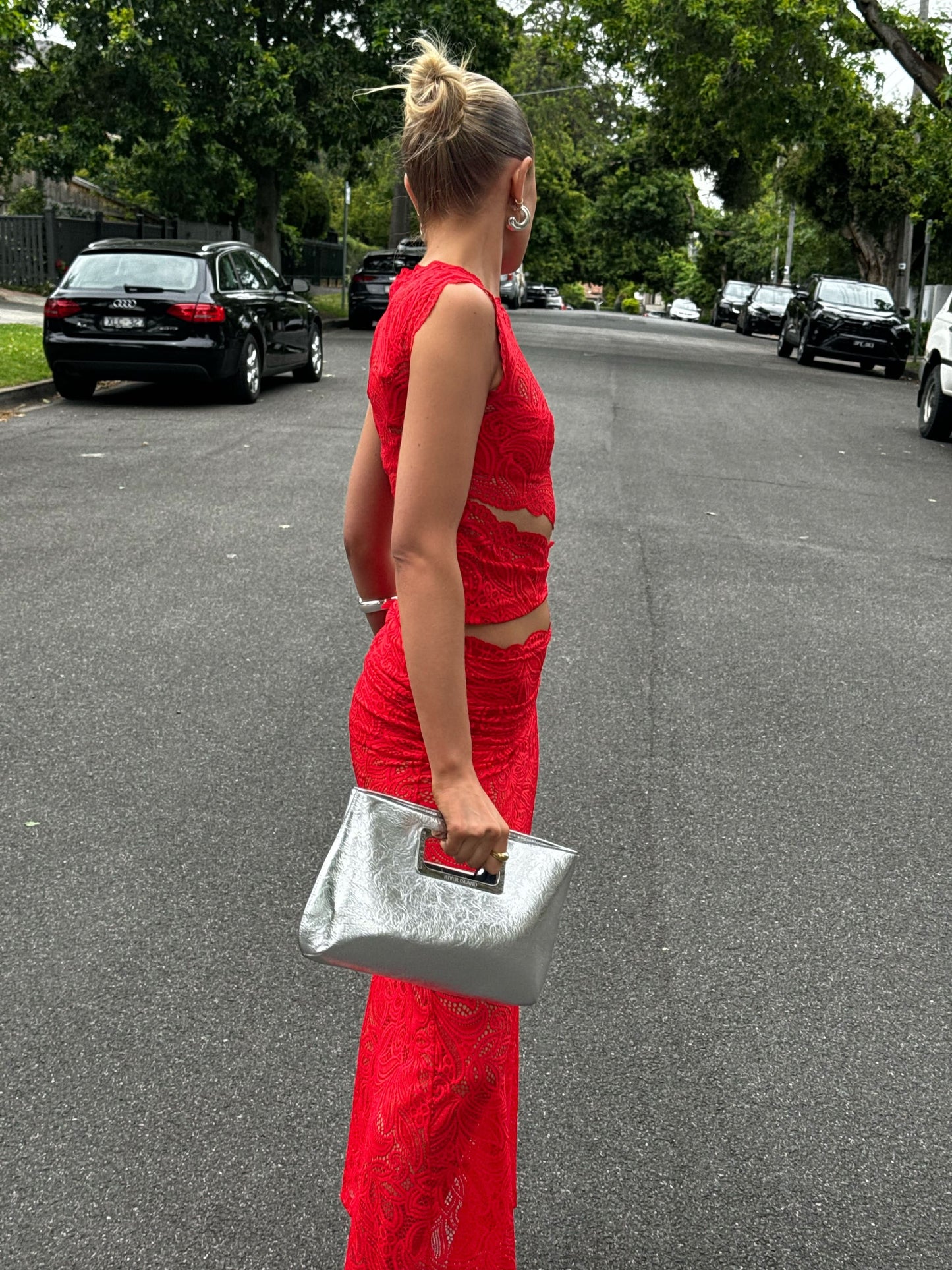 Side view red lace two-piece maxi skirt set with waist cutouts and fitted bodycon silhouette