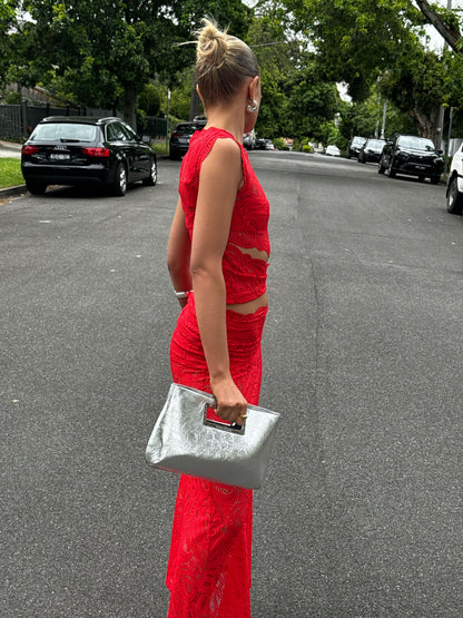 Side view red lace two-piece maxi skirt set with waist cutouts and fitted bodycon silhouette