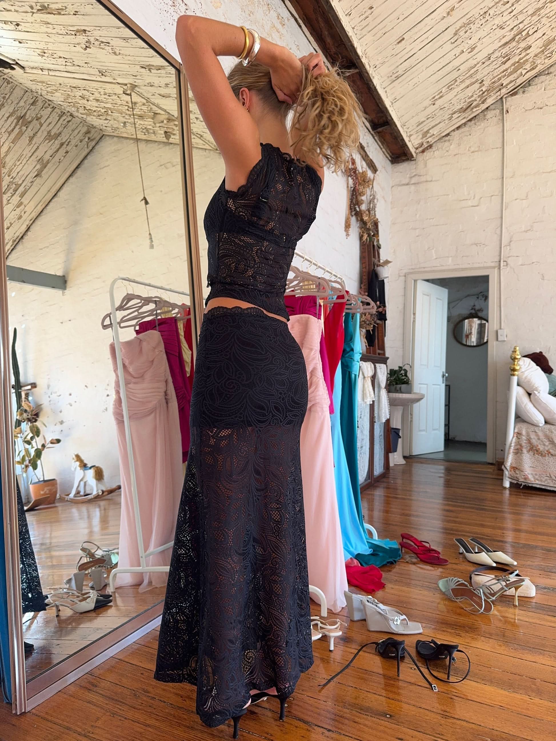 Rear angle black lace two-piece maxi skirt set, fitted bodycon skirt with scalloped edges and cutouts