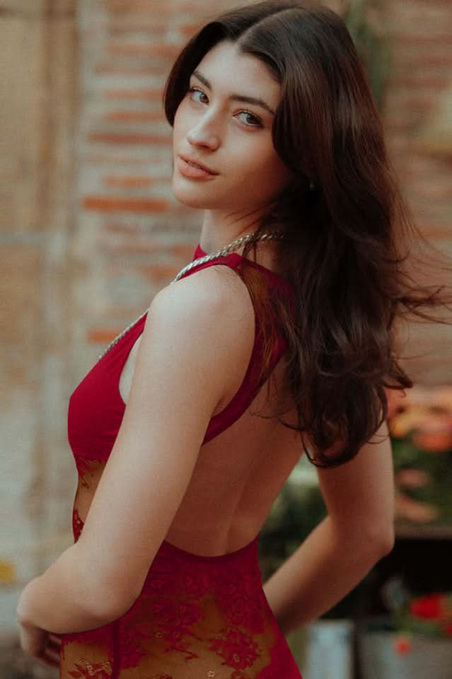 Back view of a red lace cutout maxi dress with an open back, featuring intricate floral lace detailing on the skirt.