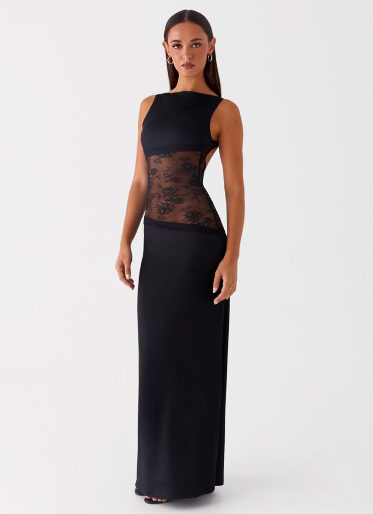 Side view of black sleeveless cocktail maxi dress featuring a sheer floral lace cutout on the side.