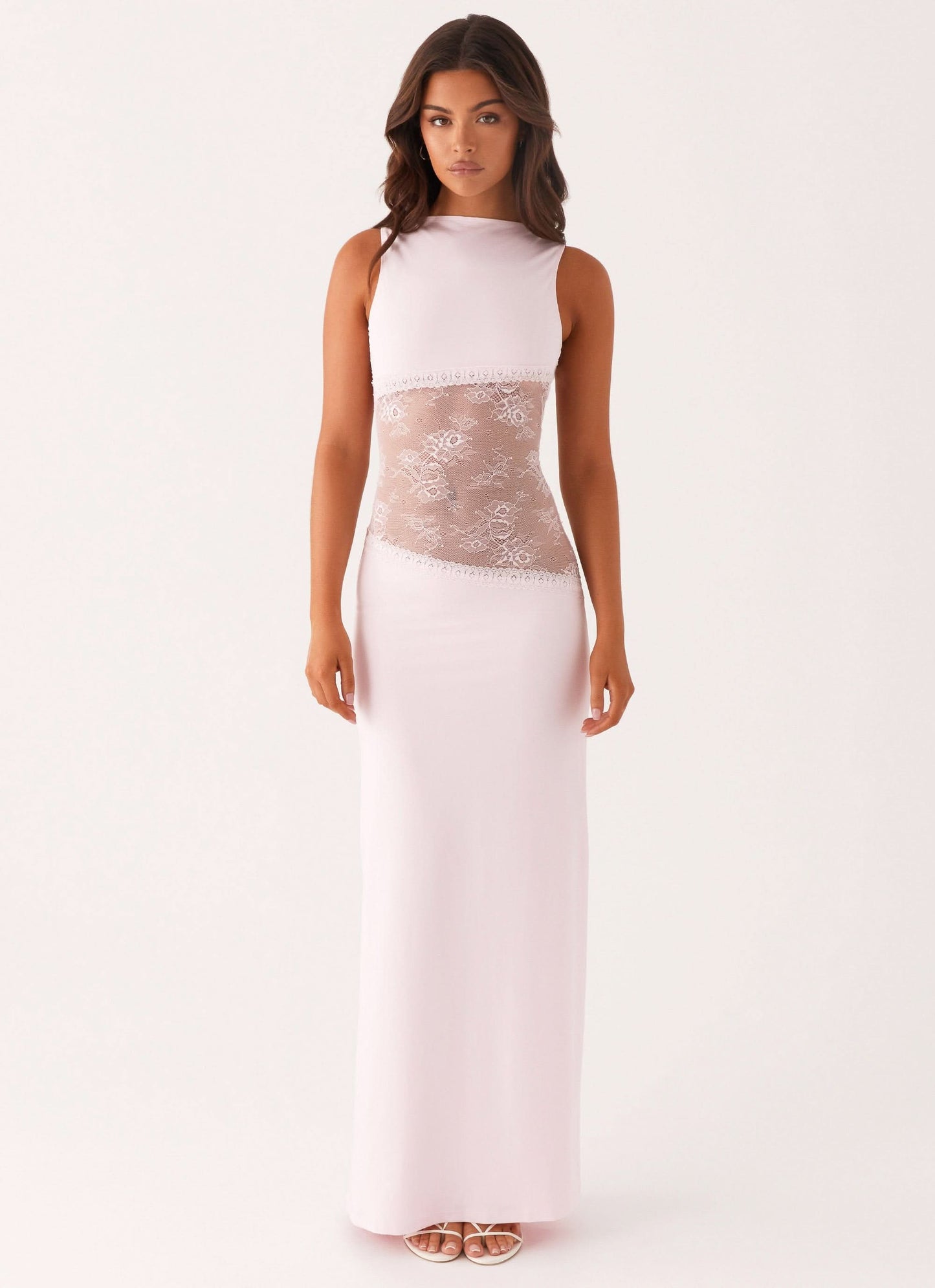 Pale pink sleeveless cocktail maxi dress with sheer white floral lace cutout waist, front view.