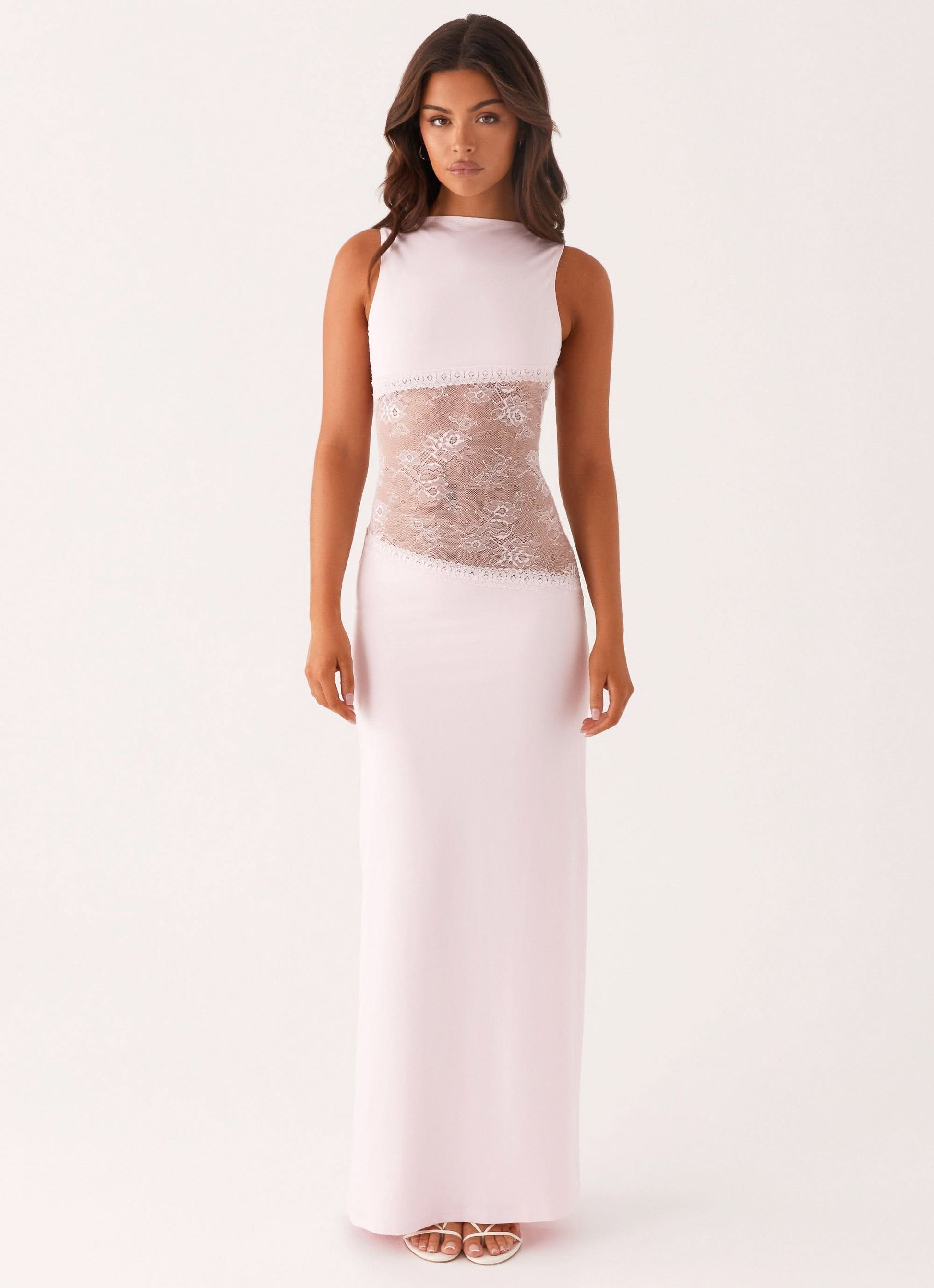 Pale pink sleeveless cocktail maxi dress with sheer white floral lace cutout waist, front view.
