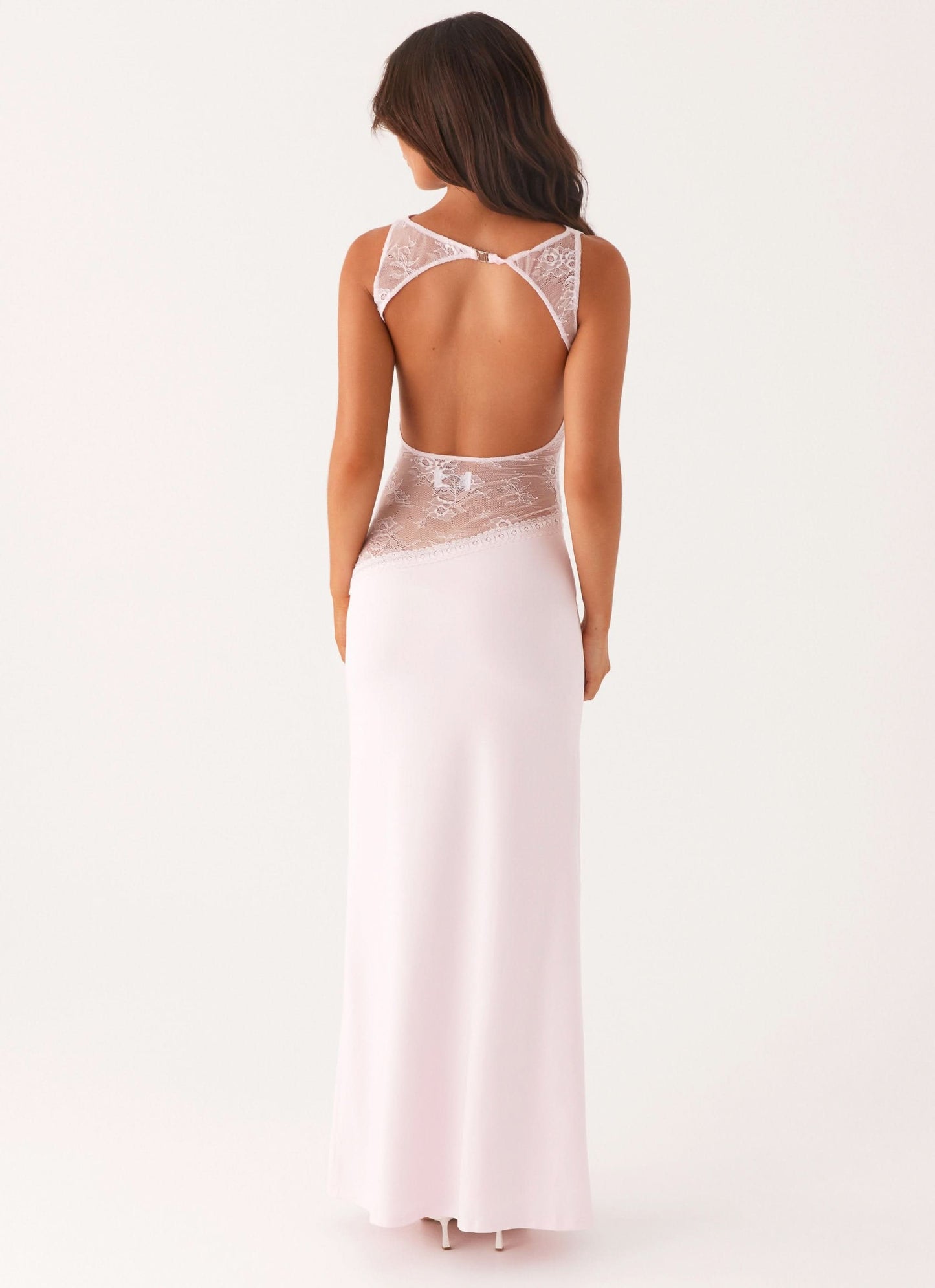 Back view of pale pink cocktail maxi dress with open back and white floral lace panels.