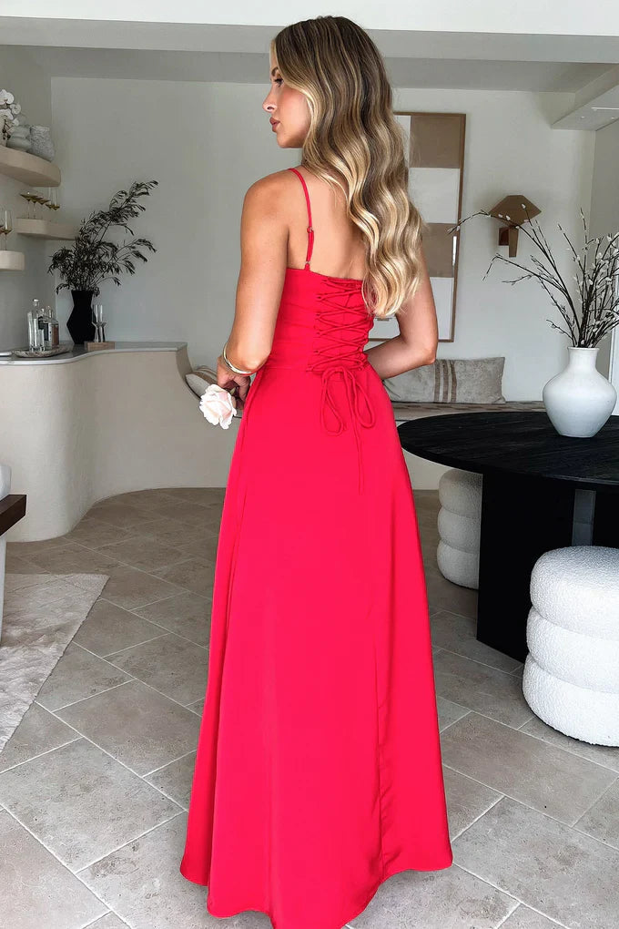 Back view of a woman in a red sleeveless maxi dress, highlighting the intricate lace-up back detail and flowing skirt, ideal for vacation outfits.
