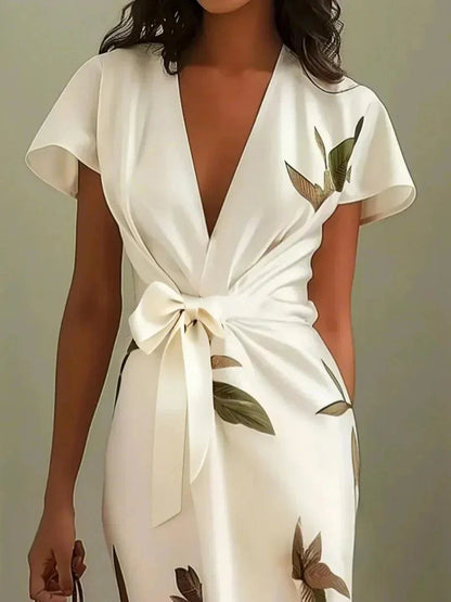 Front view ivory leaf print wrap maxi dress with knotted tie waist and overlapping skirt opening