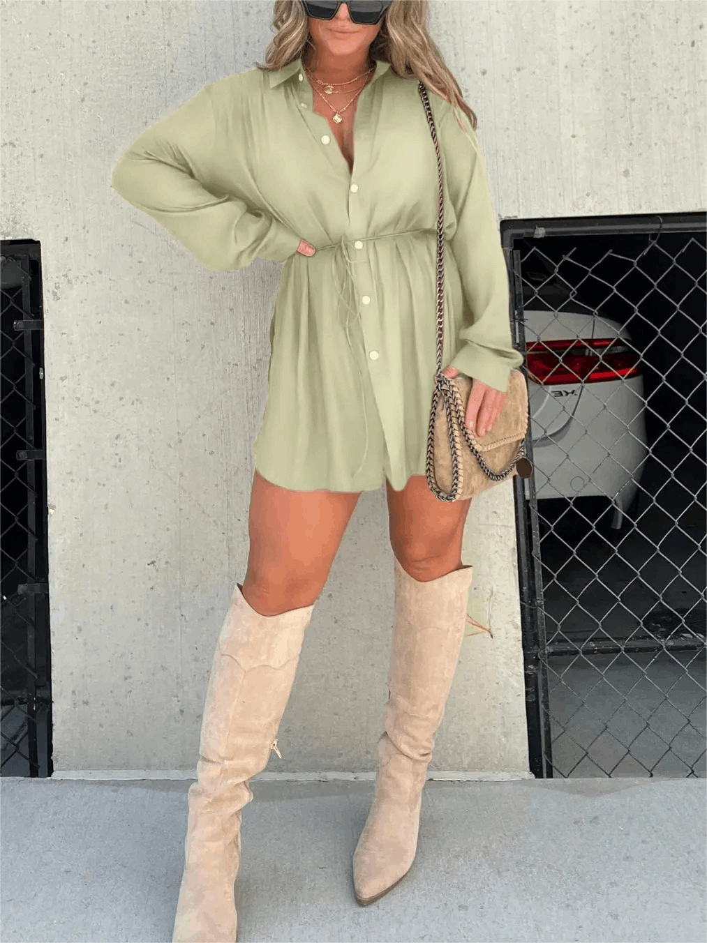 Sage green long sleeve button front mini romper featuring a collared design and adjustable waist, worn with tall boots.