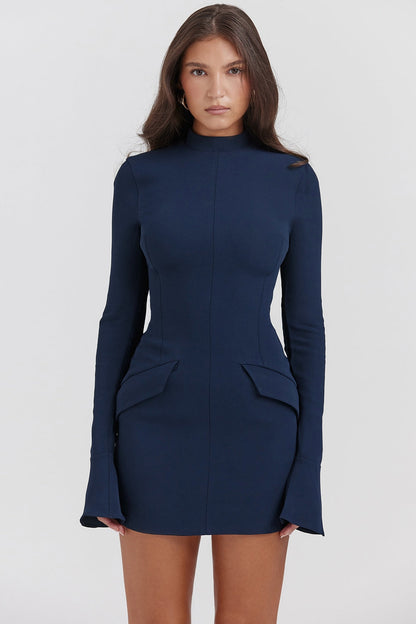 Side profile of a woman wearing a navy long sleeve high neck mini dress, showcasing the fitted silhouette.