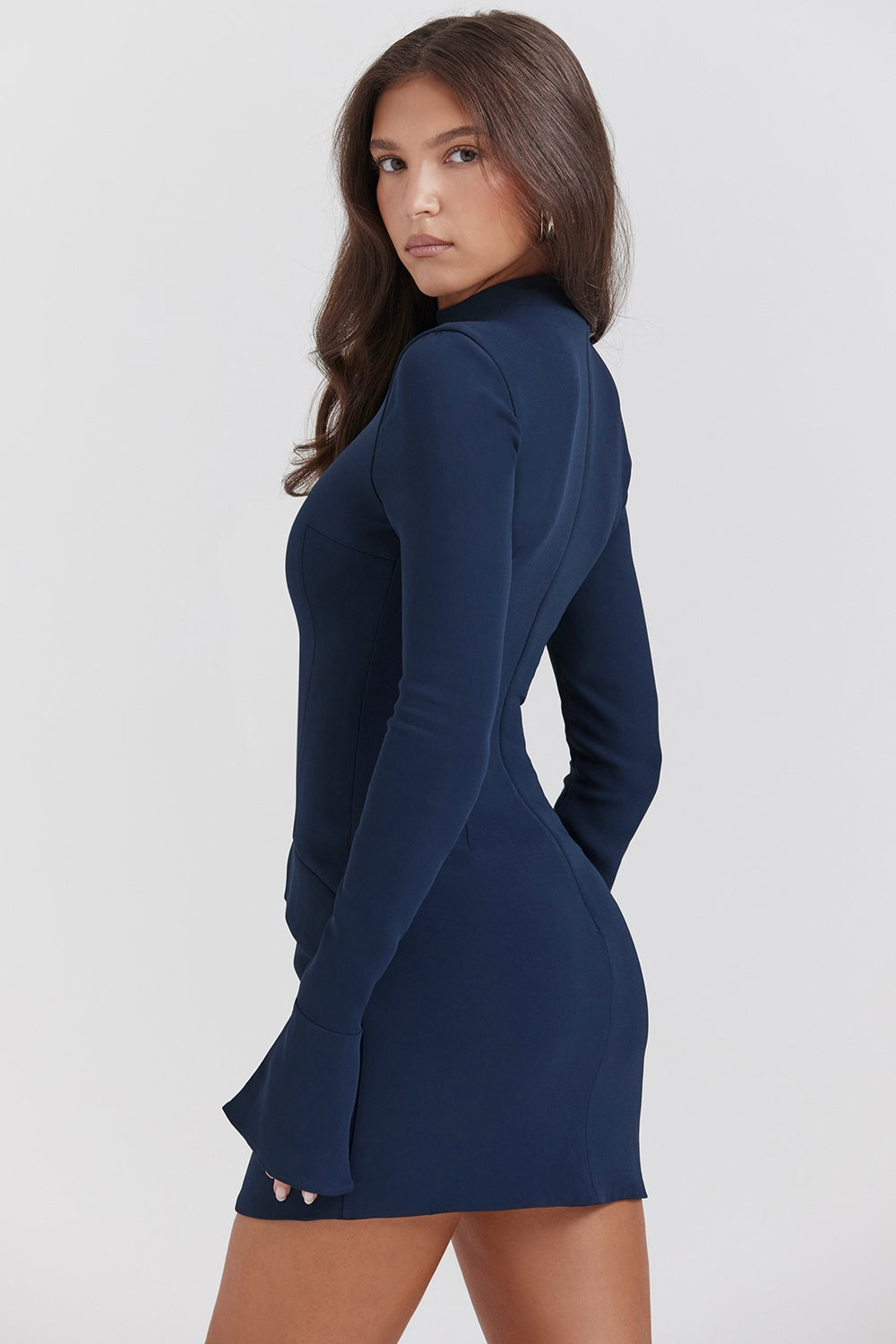 Full-length front view of a navy long sleeve high neck mini dress with flared cuffs and pocket details.