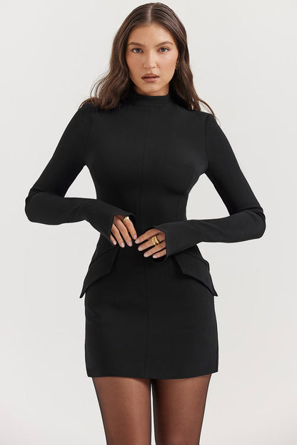 Side profile of a woman in a black long sleeve high neck mini dress, showing the bodycon fit and tights.