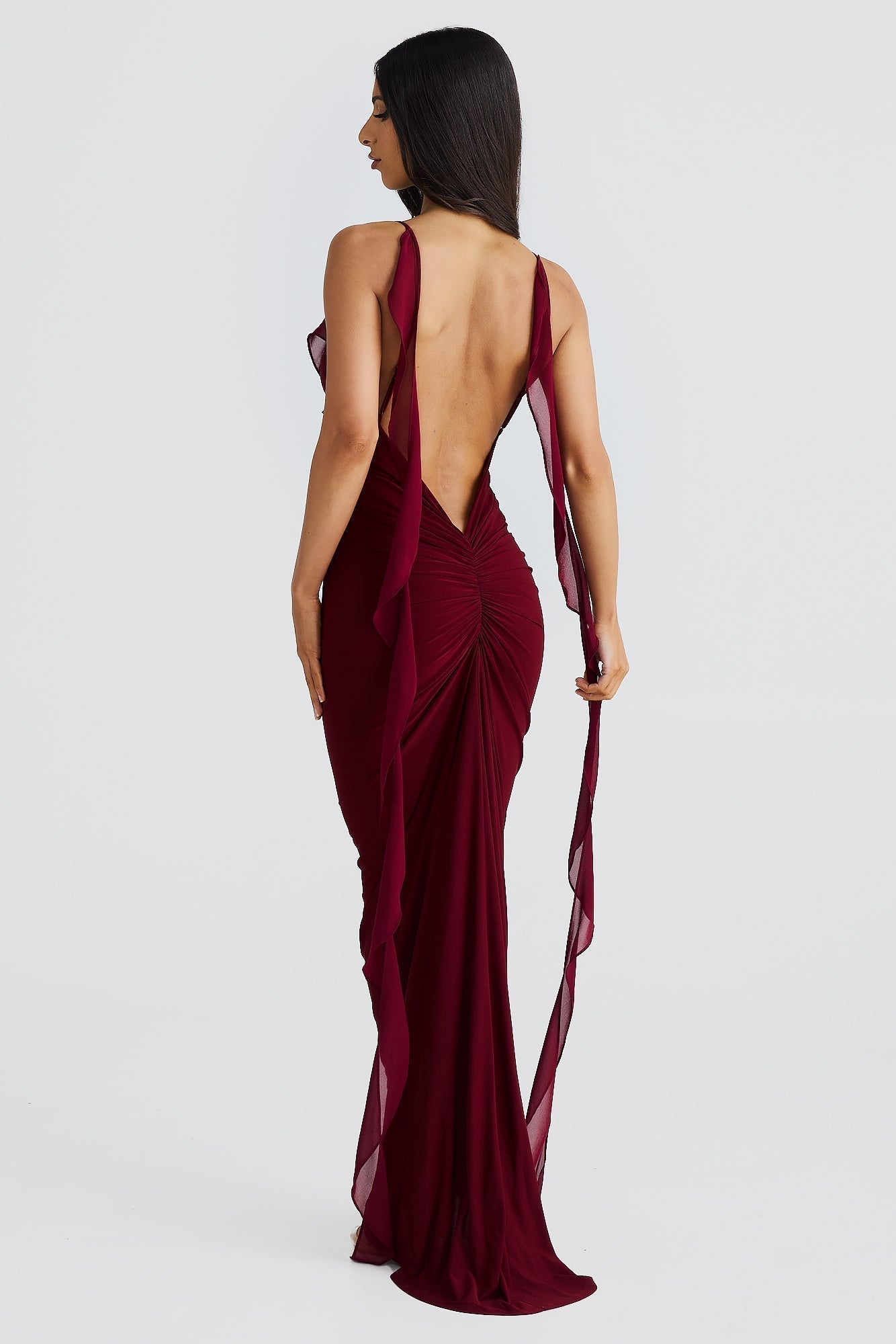 Back view of burgundy low back maxi dress with ruched detail and sheer shoulder straps, elegant dresses for wedding guests