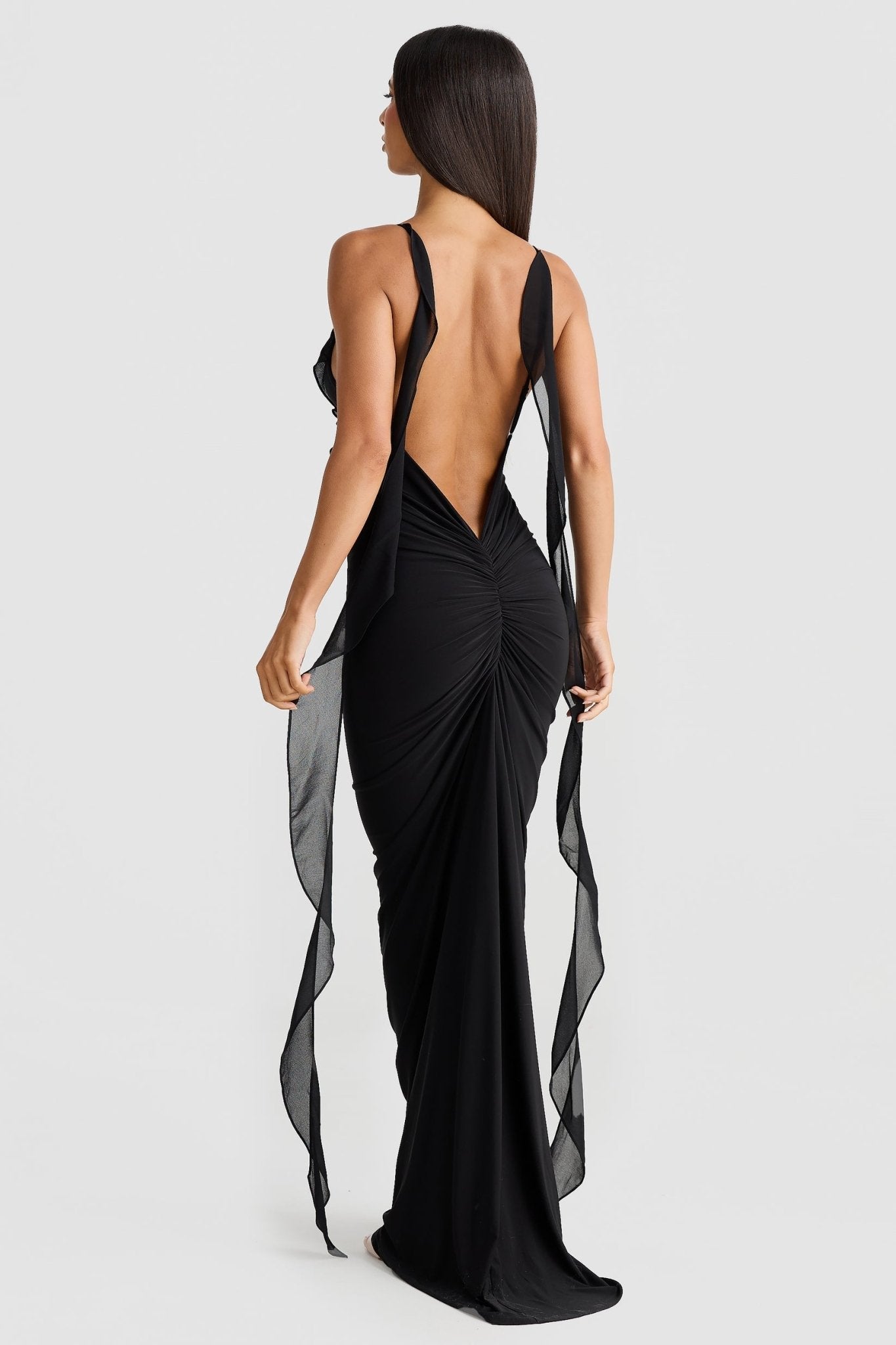 Back view of black low back maxi dress with sheer shoulder straps and ruched detail, elegant dresses for wedding guests